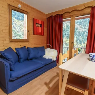 Salon en bois du CozyLodge avec vue sur la forêt